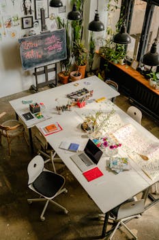 Overhead view of a creative art workspace featuring calligraphy tools and supplies on a large table.
